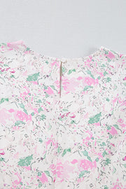 Blush pink floral print blouse with smocked waist detail and button closure at back neck.