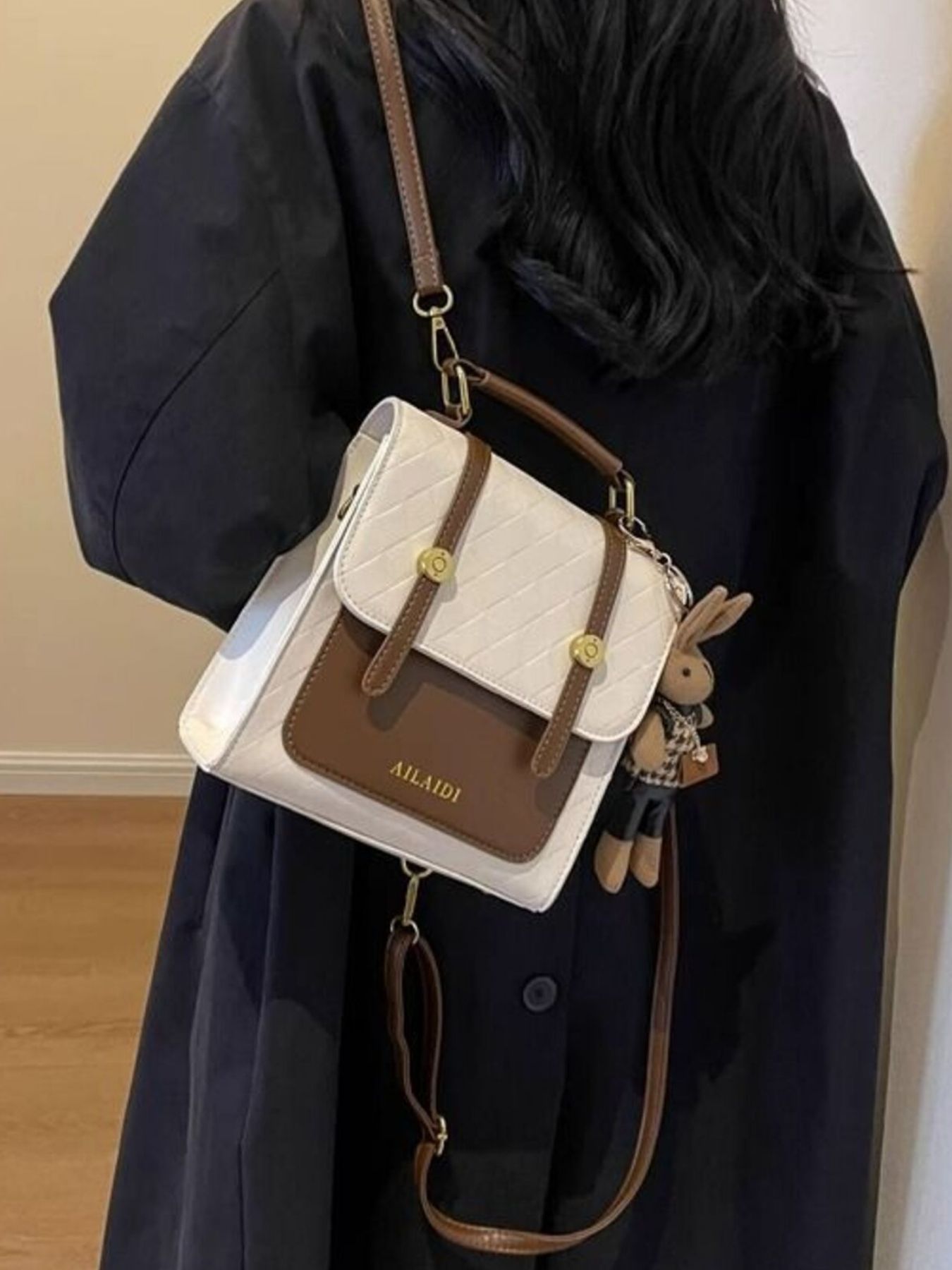 Mini quilted flap backpack bag in white and brown with gold hardware and bunny charm.
