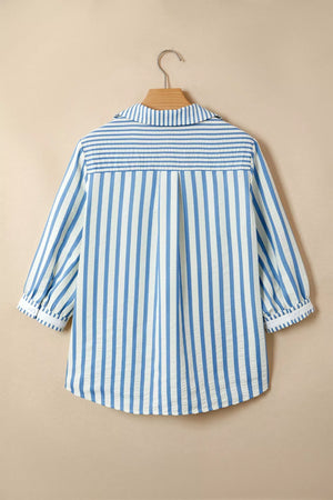 Blue and white striped cotton collared blouse with smocked yoke and cuffed sleeves.