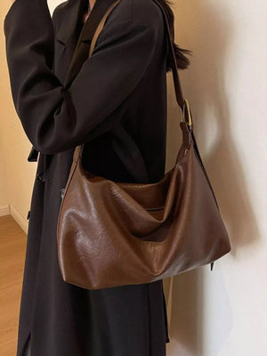 Brown faux leather shoulder bag with adjustable strap and gold buckle detail
