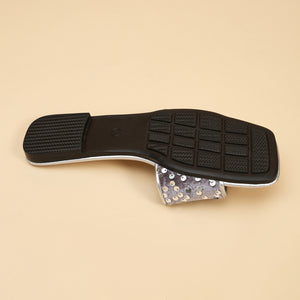 Silver sequined open-toe sandal with a black sole and textured tread.