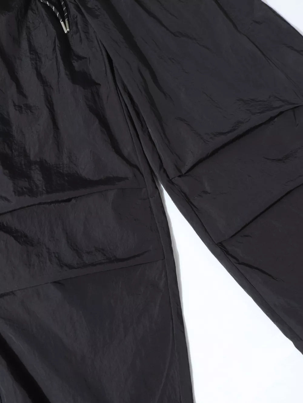 Black wide-leg cargo pants with large flap pockets and drawstring waist.