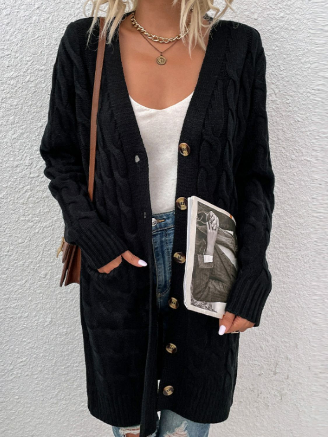 Black cable knit button-down cardigan with pockets and a V-neckline.
