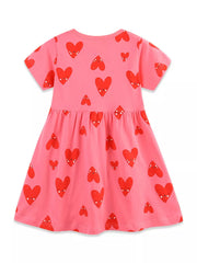 Pink cotton baby dress with playful red heart print, short sleeves, and gathered waist.