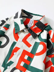 Men's long sleeve shirt in cream with bold red, green, and black letter print, button-down front.
