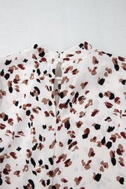 White high-neck blouse with abstract print and button-back detail