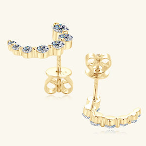 Gold celestial arc moissanite stud earrings with a curved design and sparkling stones.