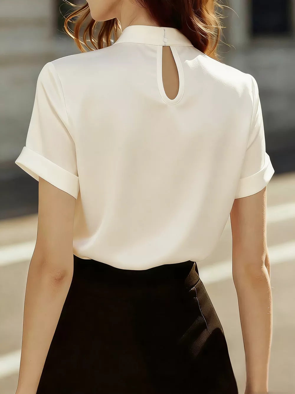 Cream satin blouse with short rolled sleeves and a keyhole neckline detail.