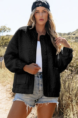 Black quilted bomber jacket with textured floral pattern, elastic cuffs, and patch pockets.