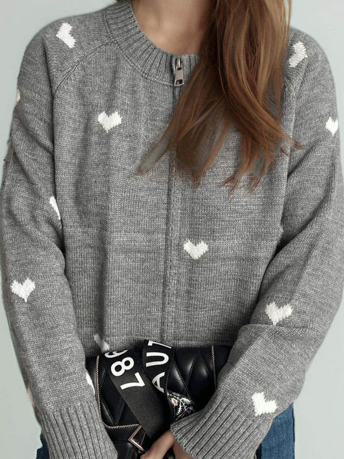 Gray zip-through knit sweater with allover white heart print and crew neck.