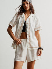 White two-piece set with geometric embroidery, button-up shirt, and shorts.