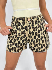 Leopard print high-waisted denim shorts with raw hem and button fly.