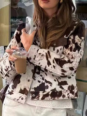 Buttoned collared jacket in cow print with button front and brown accents.