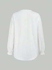 White oversized tunic top with ruffled cuffs and long sleeves.