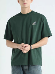 Men's dark green cotton graphic tee with embroidered detail and text.