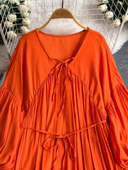 Orange bohemian maxi dress with balloon sleeves, V-neck, and tie waist.