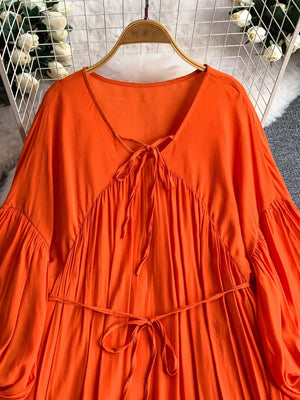 Orange bohemian maxi dress with balloon sleeves, V-neck, and tie waist.