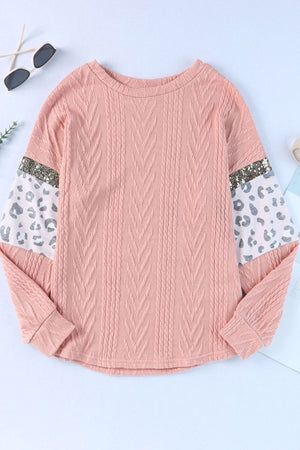 Pale blush sweater with textured chevron body and leopard print sleeves with sequin trim.
