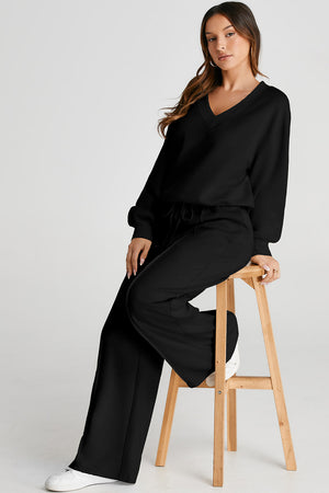 Black V-neck lounge set with seam detail on wide leg pants and relaxed fit top.