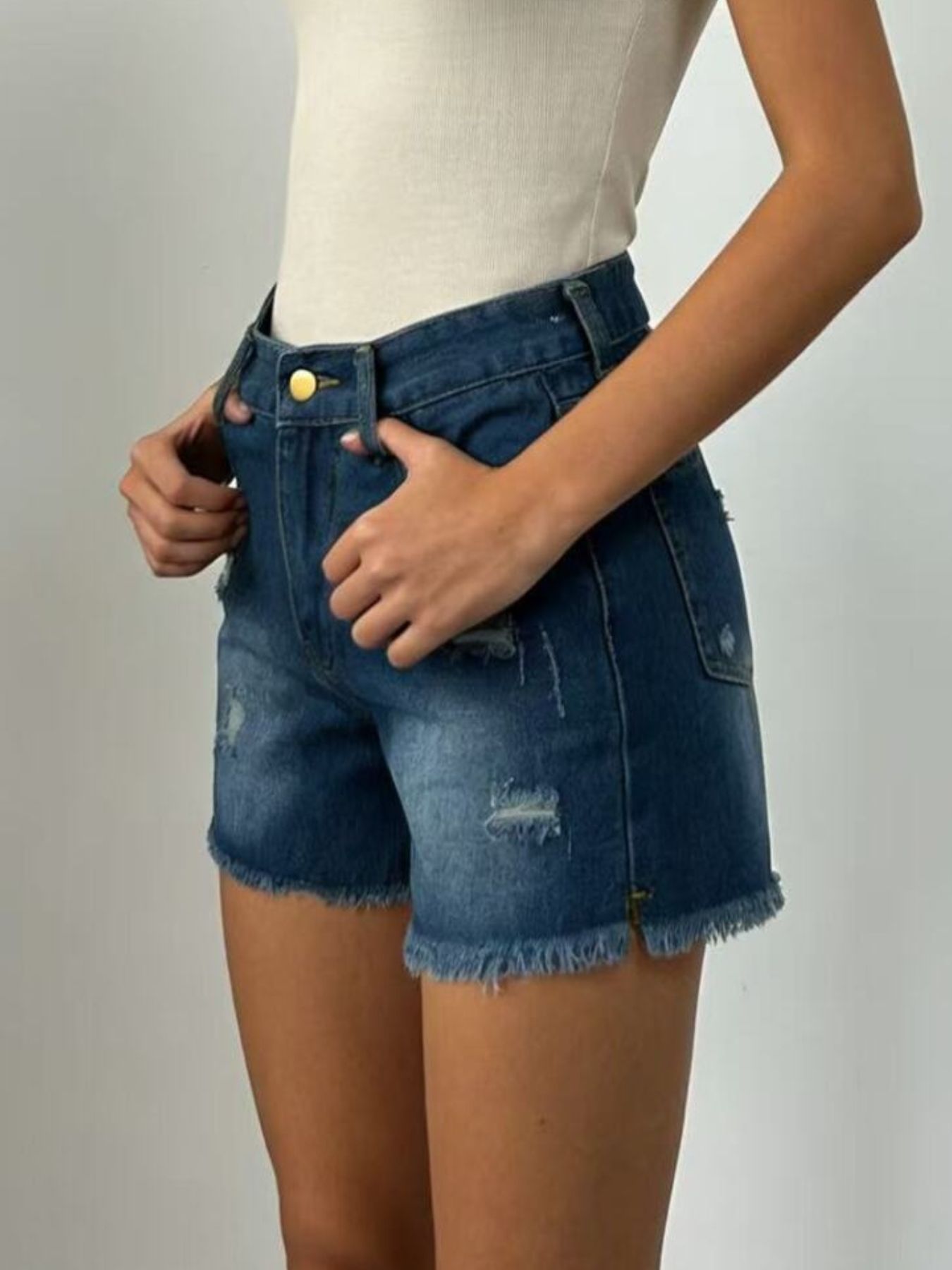 Dark blue distressed denim shorts with frayed hem and high waist.