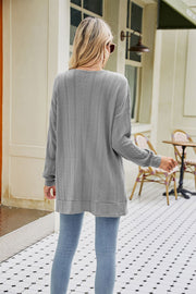 Grey cable-knit cardigan with textured chevron pattern and long sleeves.