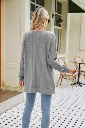 Grey cable-knit cardigan with textured chevron pattern and long sleeves.