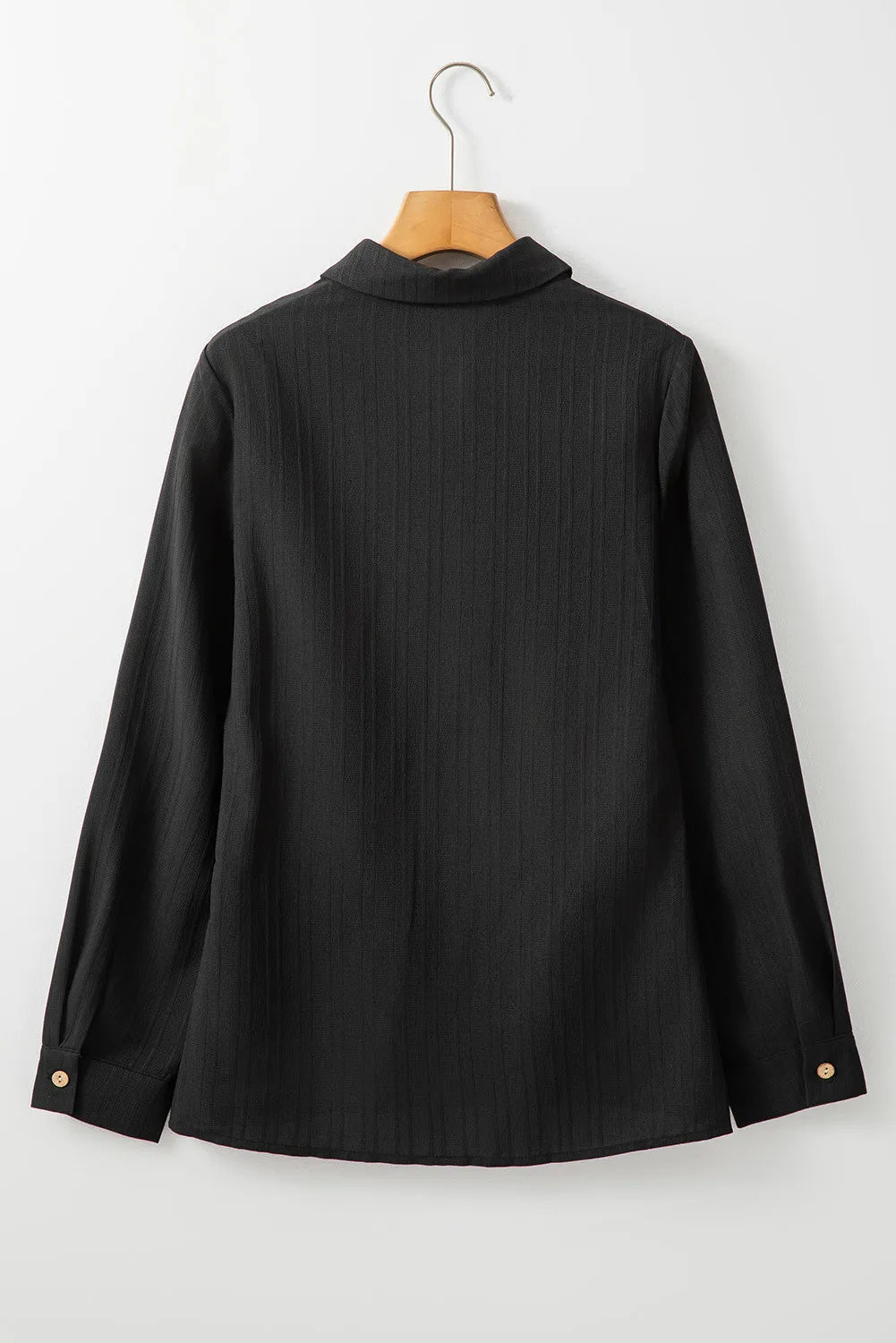 Black textured ribbed button-down shirt with long sleeves and button cuffs.