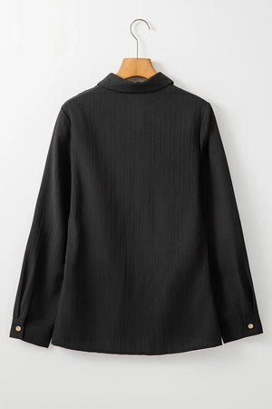 Black textured ribbed button-down shirt with long sleeves and button cuffs.
