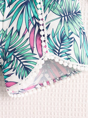 Baby floral shorts with white pom-pom trim and tropical leaf print.