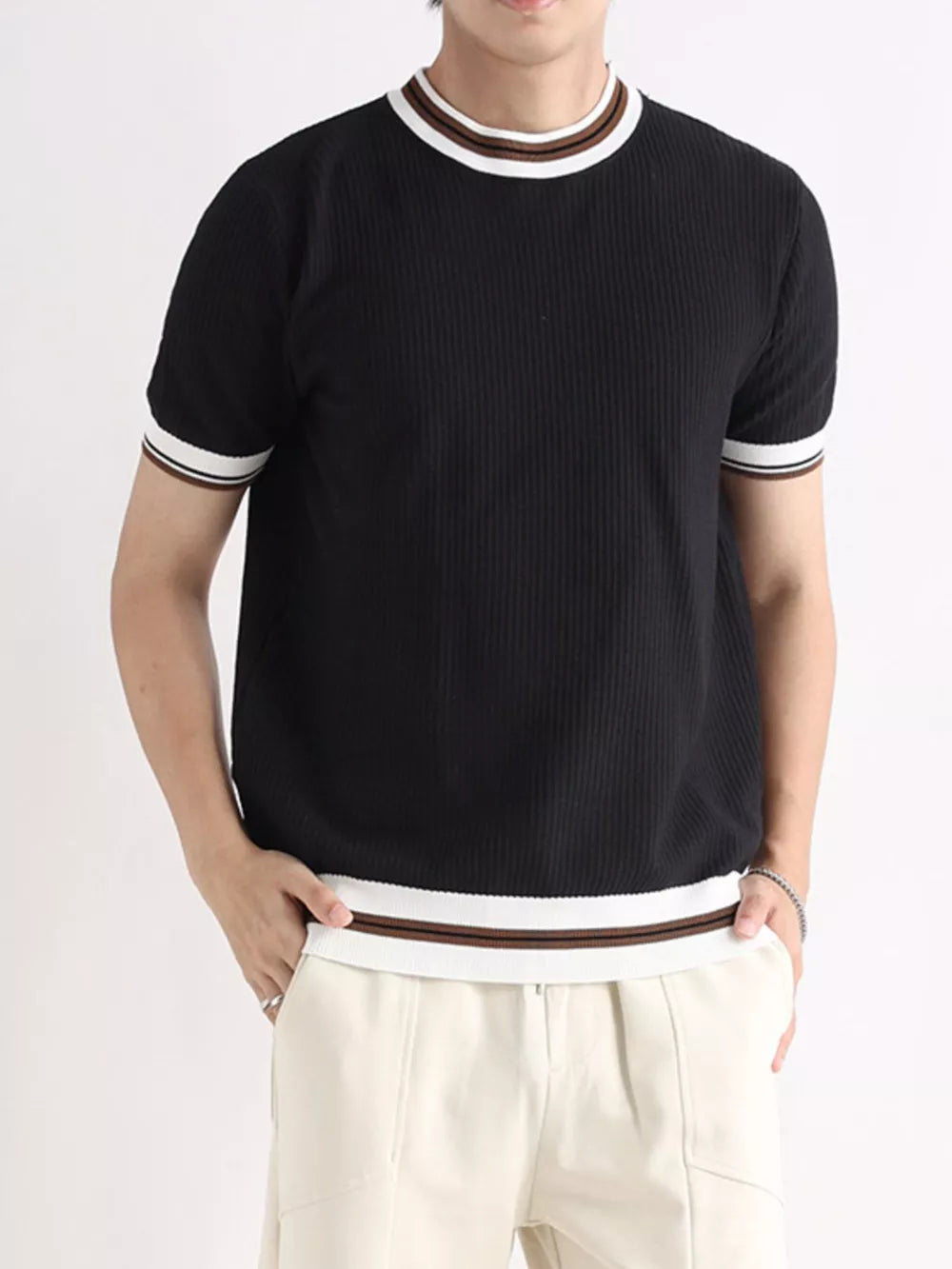 Textured ribbed black crew neck t-shirt with white and brown striped trim on collar and sleeves.