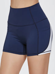Dark blue activewear shorts with white colorblock detail and pockets.