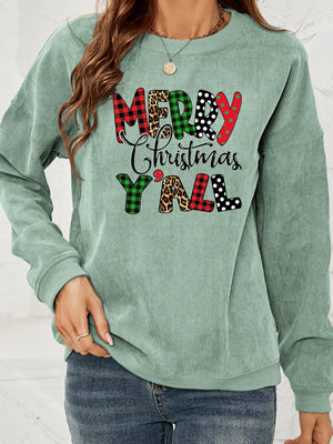 Sage corduroy sweatshirt with Merry Christmas Y'all graphic in buffalo plaid, leopard, and polka dot patterns.