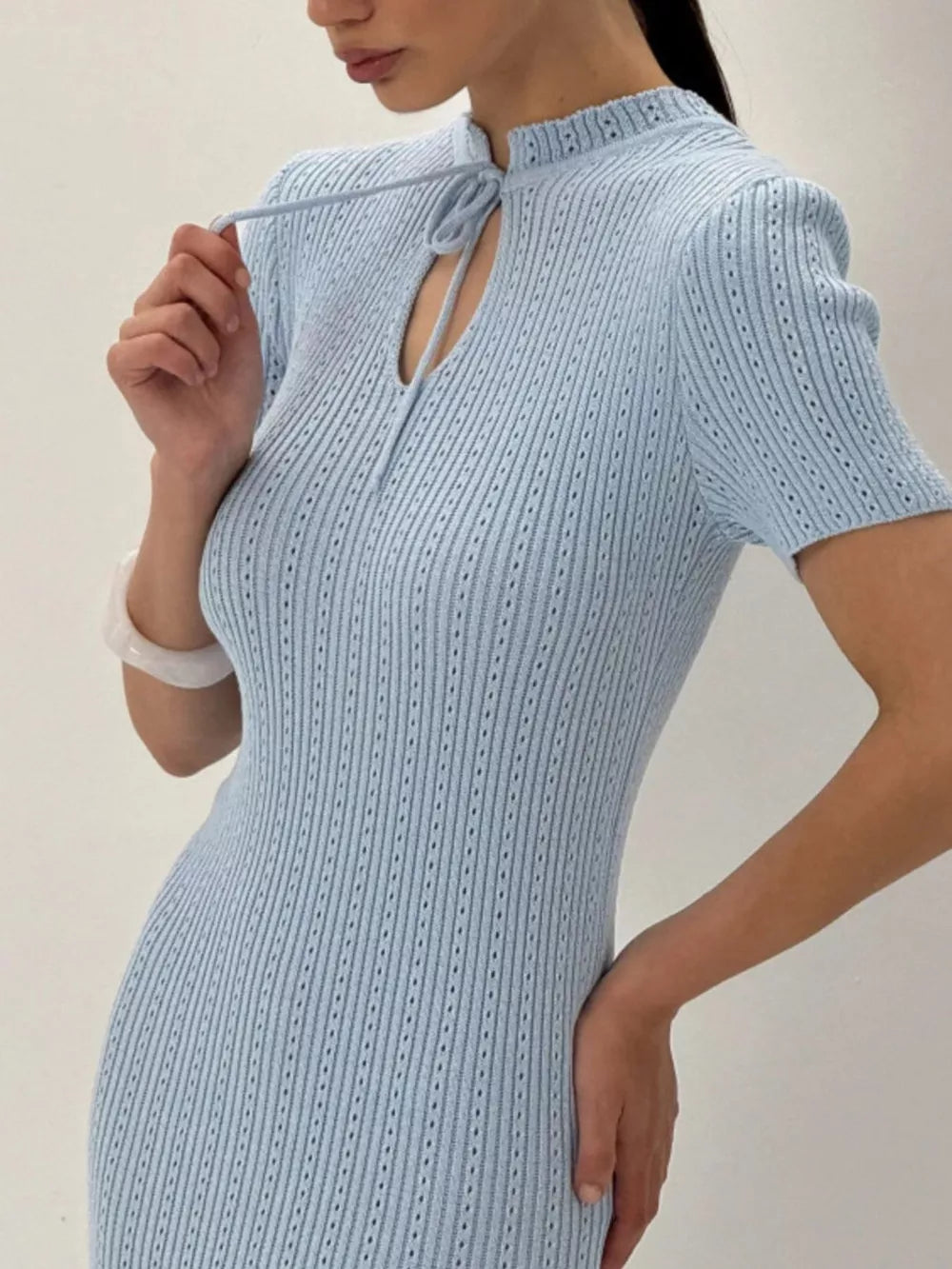 Light blue knitted mermaid dress with tied neckline and short sleeves.