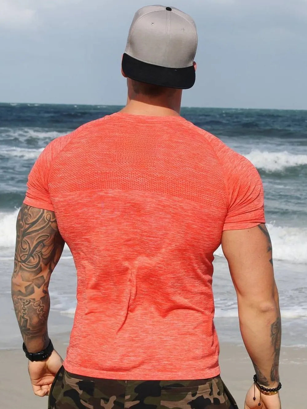 Coral performance knit t-shirt with seamless texture detail, short sleeves, and crew neck.