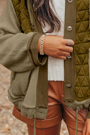 Olive quilted panel waffle knit hoodie with ribbed sleeves and button closure.