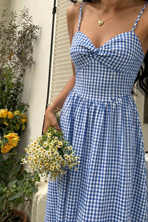Blue gingham midi dress with knot-front sweetheart neckline and spaghetti straps.