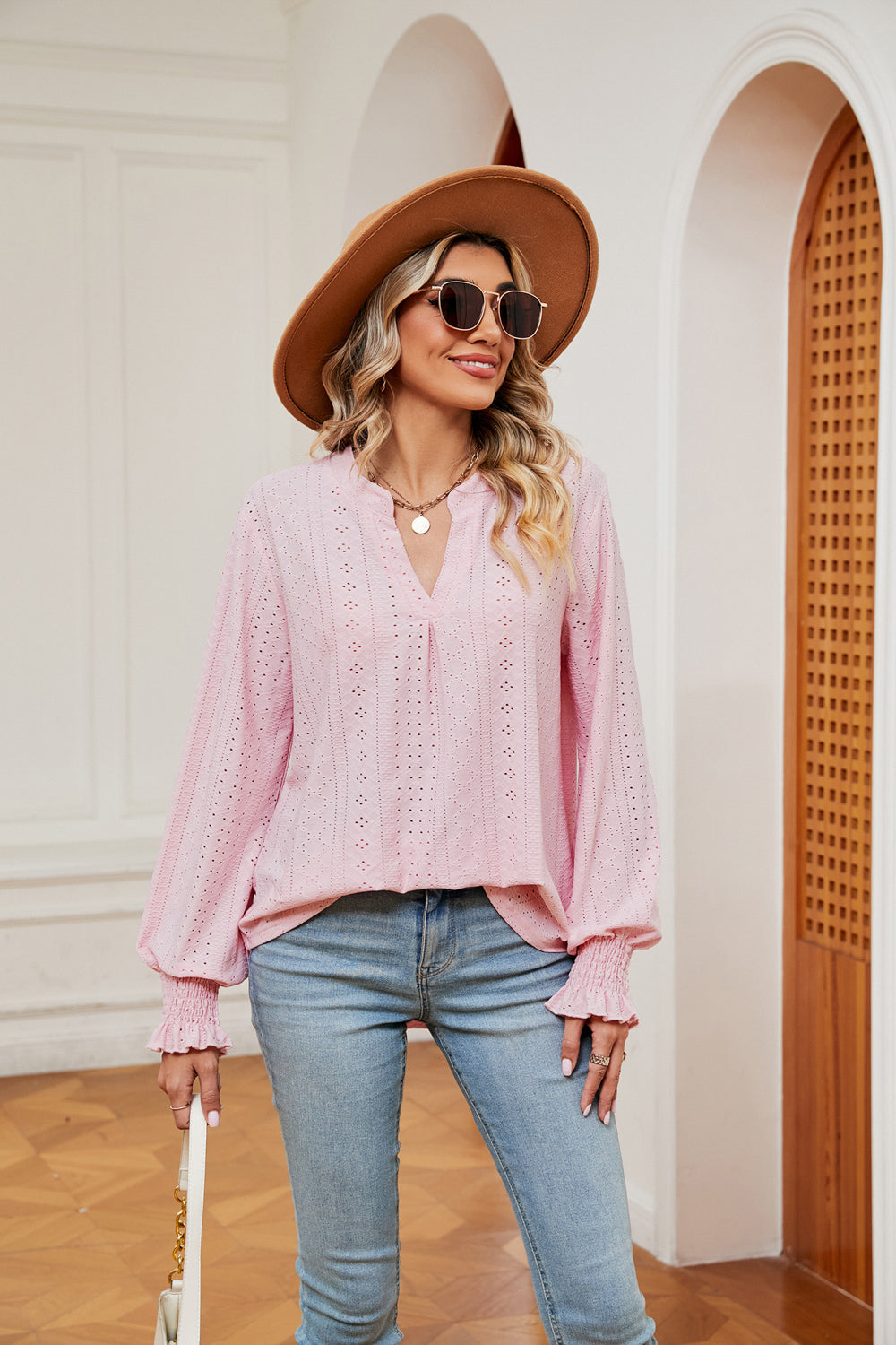 Blush pink eyelet detail poet sleeve blouse with v-neck and ruffled cuffs.