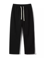 Black loose-fit men's sweatpants with drawstring and pockets.