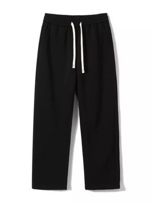 Black loose-fit men's sweatpants with drawstring and pockets.