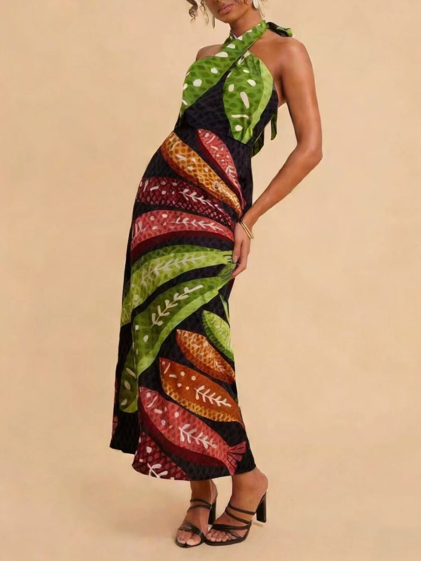 Tropical print halter neck midi dress with a flowing skirt and leaf motifs.