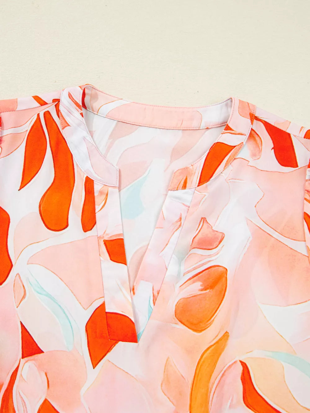 Vibrant abstract print mini dress with a V-neck and collar detail.