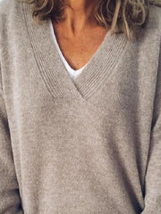 Relaxed V-neck ribbed knit sweater in tan, layered over a white tee.