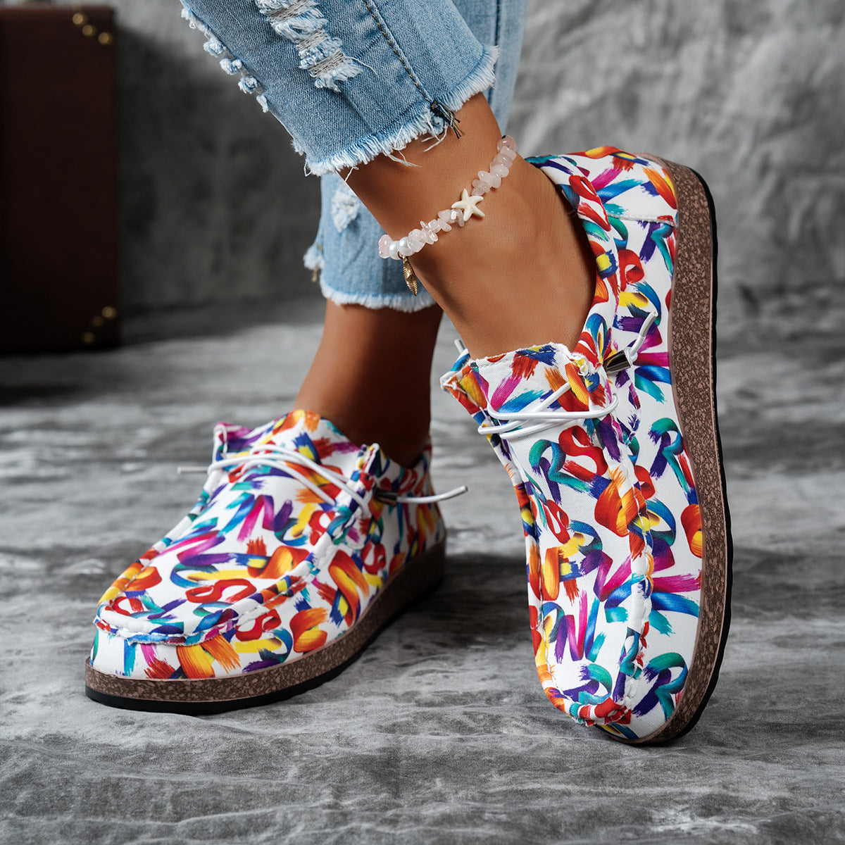 Printed casual slip-on loafers with abstract brushstroke pattern in white with multicolor accents.