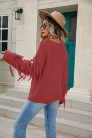 Rust knit sweater with fringe sleeves and a relaxed fit.