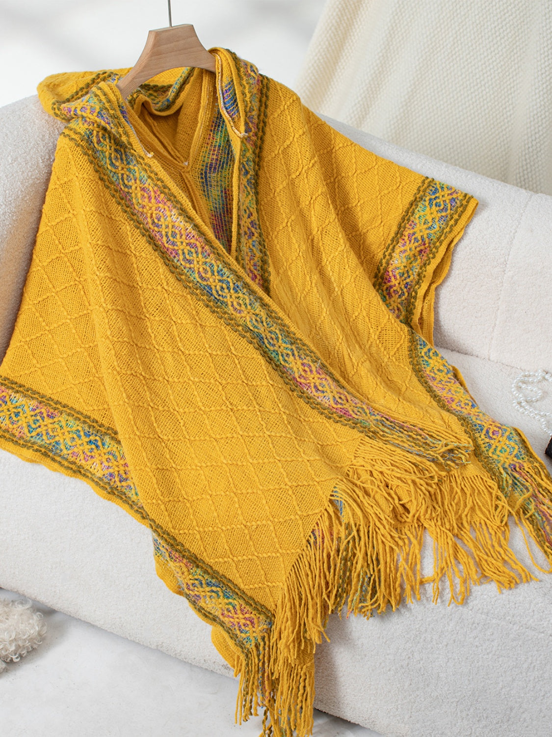 Mustard yellow knit hooded wrap with diamond pattern and colorful embroidered trim.