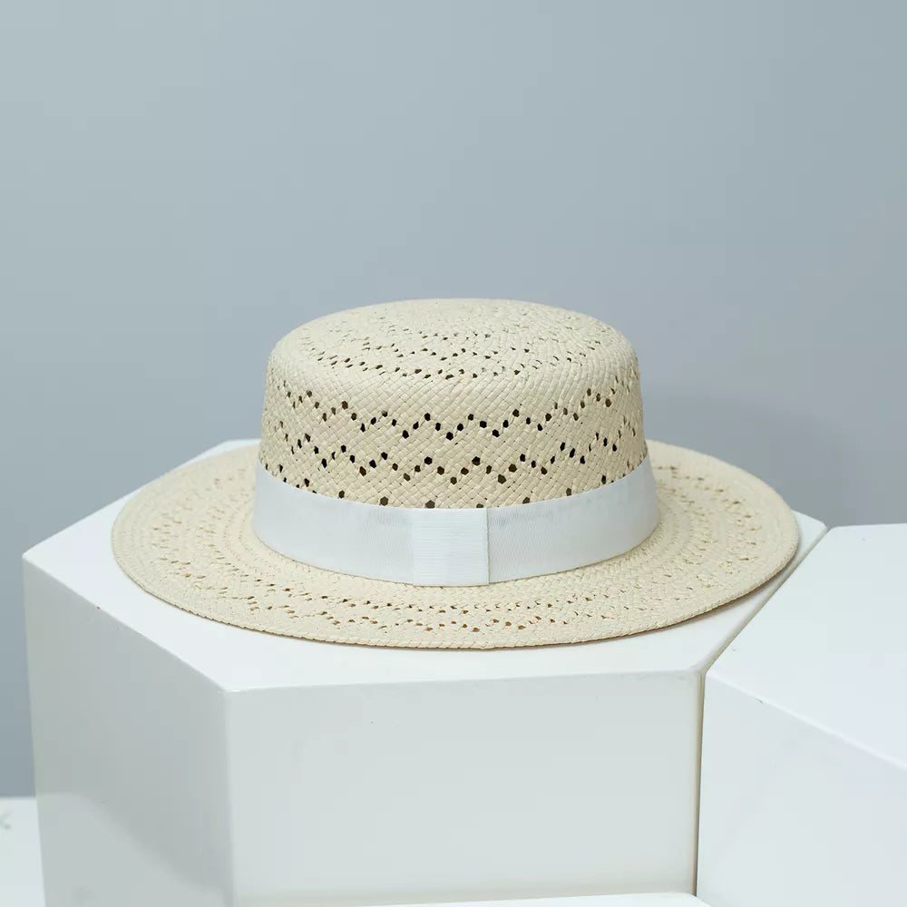 Off-white woven straw boater hat with white ribbon band and eyelet pattern