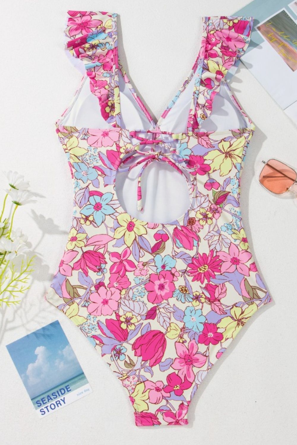 Floral ruffle backless swimsuit with lace-up back and cutout detail in fuchsia pink.