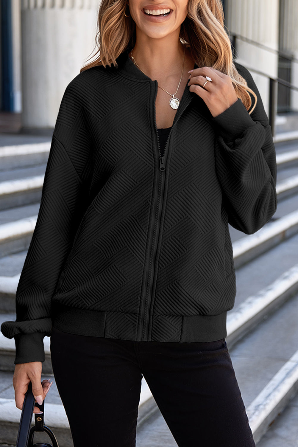Black bomber jacket with diamond quilting and zip front.