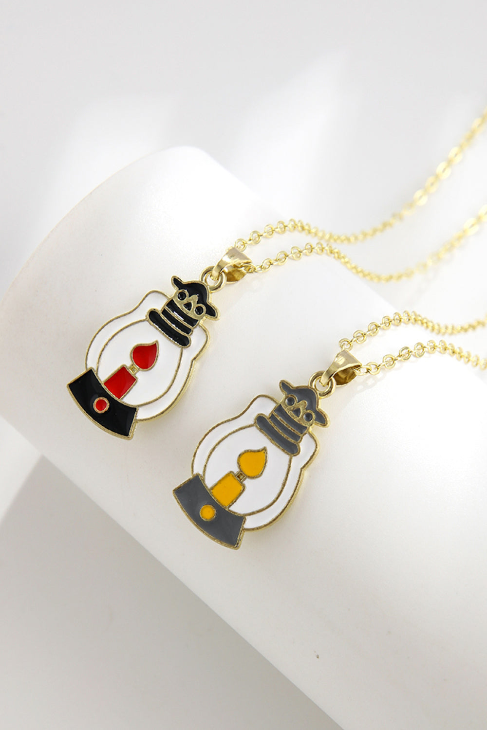 Spooky Season enamel pendant necklaces, one with red flame, one with yellow flame.