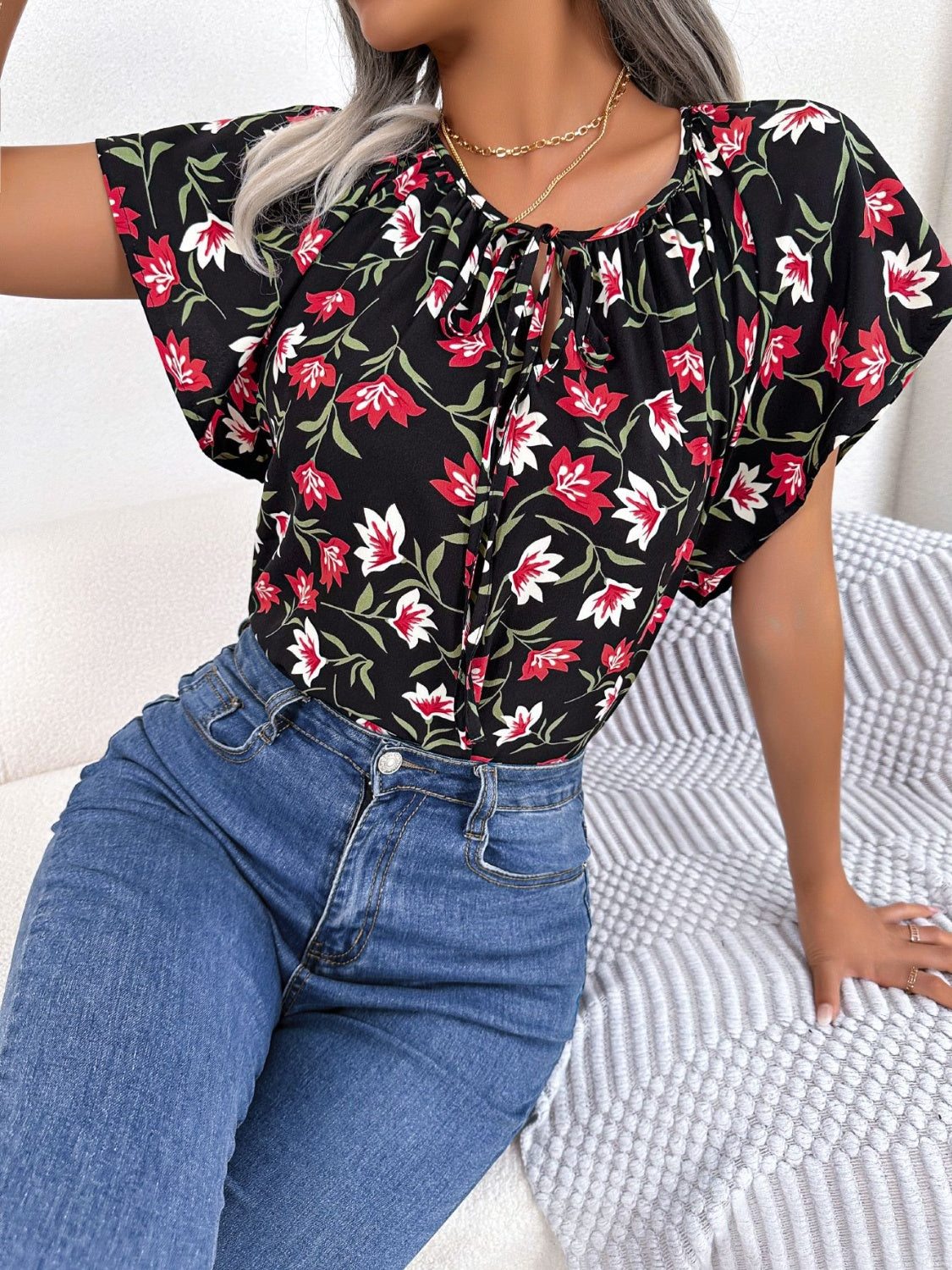Black floral ruffle sleeve tie-neck blouse with red and white flowers